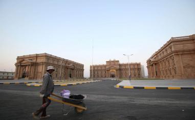 عامل يمر بالقرب من أبنية جامعية في البصرة