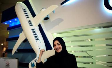 مرأة  سعودية قرب مجسم طائرة 