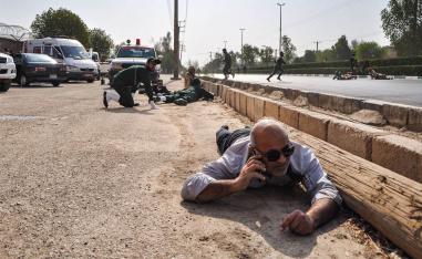 أفراد من الحرس الثوري الإيراني يحتمون من اطلاق النار في عرض عسكري في الأحواز