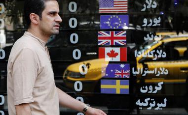 إيراني يمر بجانب محل صرافة في طهران