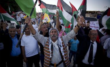 Palestinians protesters fly national flags and chant anti Israel slogans in the West Bank hamlet of Khan al-Ahmar 