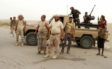 Yemeni pro-government forces stand next to a pickup truck carrying anti-aircraft guns outside Hodeidah