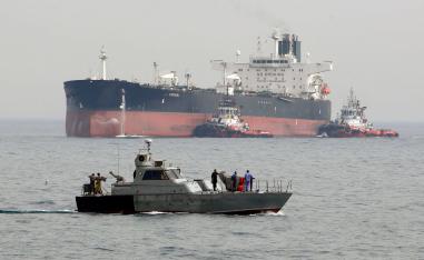 An Iranian military speedboat patrols the waters as a tanker perpares to dock at the oil facility in the Khark Island