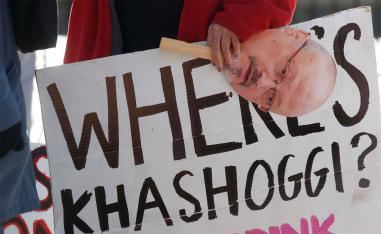 An activist holds a sign and image of missing Saudi journalist Jamal Khashoggi during a demonstration in Washington