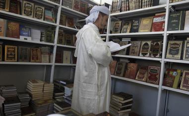 جزائري يتصفح كتبا دينية في معرض الجزائر للكتاب