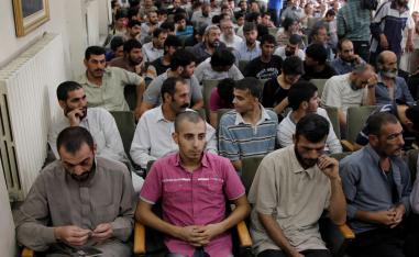 Syrian detainees, who were arrested over participation in protests against Syrian President Bashar al-Assad's regime, are seen waiting to sign their release papers at a police building in Damascus October 24, 2012. 
