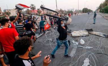 In this file photo taken on September 2, 2018, Iraqi protesters gather trash cans and scrap with barbed wire as they erect a make-shift barricade during clashes with security forces following a demonstration against corruption and lack of basic services outside the local government headquarters in the southern city of Basra.