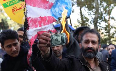 إيراني يحرق دولار أميركي في تظاهرة احتجاج على عودة العقوبات