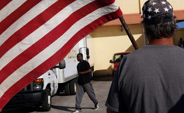 A man holding a flag insults verbally another man outside Broward County election offices during a ballot recount in Lauderhill, Florida, US on November 12, 2018.