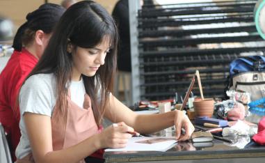Artist Oumayma Badoud working on her engravings in the workshop