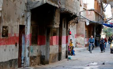 People walk in a street in Tadamun neighbourhood.