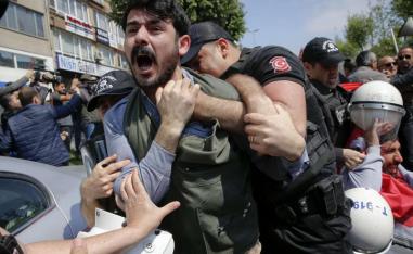 A demonstrator screams as police officers grab him during a protest in Istanbul