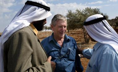 In this file photo taken on October 30, 2002 Israeli writer Amos Oz (C) talks with Palestinian men after picking olives in the West Bank village of Aqraba, south of Nablus.