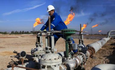 An Iraqi worker operates valves in Nihran Bin Omar oilfield, north of Basra