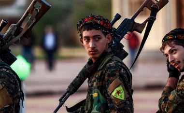 Syrian Democratic Forces fighters hold a sniper rifle 