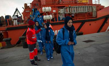 Migrants are transferred upon their arrival aboard a coast guard boat at Algeciras' harbour 