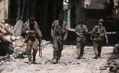 Syria Democratic Forces (SDF) fighters walk on the rubble of damaged shops and buildings in the city of Manbij, in Aleppo Governorate, Syria, August 10, 2016. 