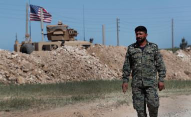 A US-backed Syrian Manbij Military Council soldier passes a US position near the tense front line with Turkish-backed fighters, in Manbij, north Syria.