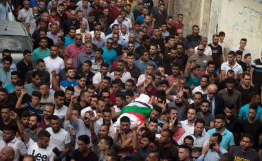 Palestinians carry the body of 48-year-old mother of eight, Aisha Rabi, who died of her wounds after the car she was travelling in with her husband was hit by stones, during her funeral in the West Bank village of Bidya, near Salfit, on October 13, 2018.
