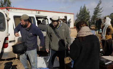 Israeli settlers move their belongings outside a caravan they had brought to the former outpost of Amona near the Jewish settlement of Ofra, following clashes with security forces as dozens of settlers were evicted early on January 3, 2019.