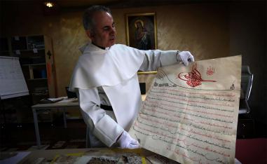 Father Najeeb Michaeel displays a manuscript at the Oriental Manuscript Digitisation Centre (CNDO) in Arbil