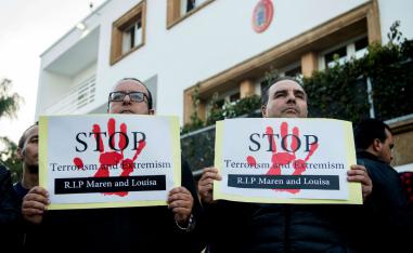 Moroccans holds placards as people pay tribute to murdered Danish Louisa Vesterager Jespersen and Norwegian Maren Ueland in Rabat, in front the Danish ambassy on December 22, 2018.