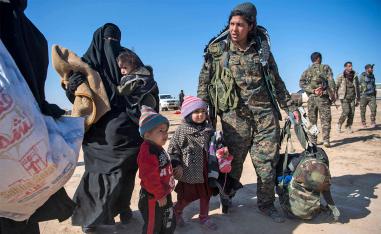 SDF fighter helps civilians fleeing from the Baghouz area