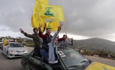 Supporters of Lebanon's Hezbollah leader Sayyed Hassan Nasrallah gesture as they hold Hezbollah flags in Marjayoun, Lebanon May 7, 2018.