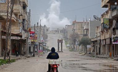 A man rides a scooter on a street during reported air strikes in the town of Khan Sheikhun in the southern countryside of the rebel-held Idlib province, on February 22, 2019.