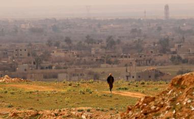 A fighter with the US-backed Syrian Democratic Forces (SDF) walks at a position in the Baghouz area in the eastern Syrian province of Deir Ezzor on February 14, 2019 during an operation to expel hundreds of Islamic State group (IS) jihadists from the region.
