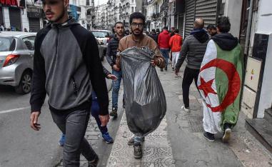 شباب متطوعون يرفعون القمامة المتخلفة بعد الاحتجاجات في الشوارع في الجزائر
