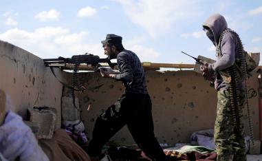 A fighter of Syrian Democratic Forces (SDF) fires a weapon in Baghouz