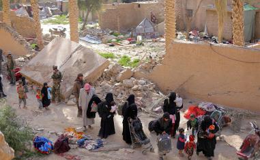 Islamic state fighters and their families walk as they surrendered in the village of Baghouz