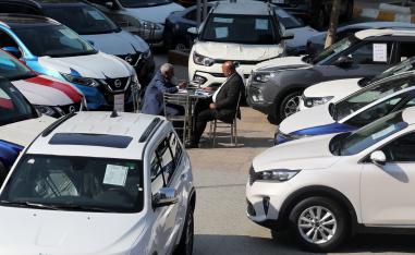 A customer sits with a sales representative at a car dealership where dozens of vehicles are on display in Cairo, Egypt, March 7, 2019.