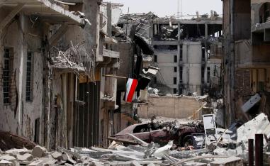 علم عراقي وسط حطام المباني في مدينة الموصل