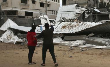 Palestinians inspect the damage of destroyed building belongs to Hamas ministry of prisoners 