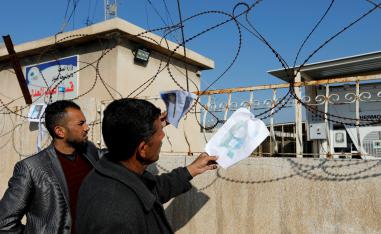 People look at pictures of victims, after a ferry sank in the Tigris river, outside a morgue in Mosul, Iraq March 22, 2019.