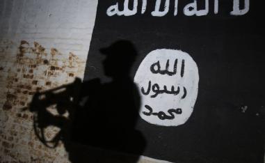 A member of the Iraqi forces walks past a mural bearing the logo of the Islamic State (IS) group in a tunnel that was reportedly used as a training centre by the jihadists in the village of Albu Sayf, on the southern outskirts of Mosul.