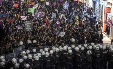 Turkish anti-riot police officers push back women during a rally marking International Women's Day on Istiklal avenue in Istanbul on March 8, 2019. 