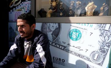 A man sits next to a gold shop and a currency exchange in Benghazi, Libya February 4, 2019.