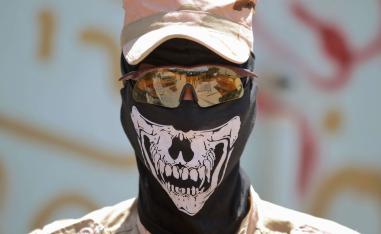 مسلح من الحشد الشعبي يرتدي قناعا