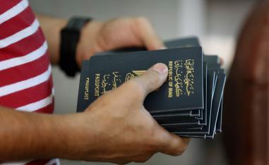 عراقي يحمل جوازات سفر في مكتب السفر في بغداد