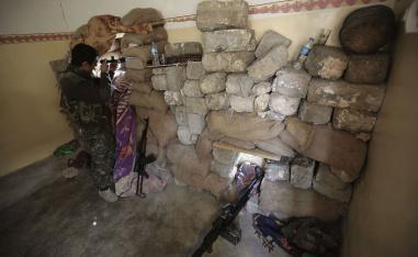 Jan. 29, 2015 photo shows a fighter of the Turkey-based Kurdish Workers' Party (PKK) uses his binoculars to look towards the Islamic State Group's base in the city of Sinjar, northern Iraq.