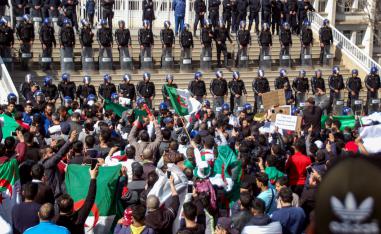 Algerians shout slogans and raise signs and national flags as they protest outside the city hall in the northern coastal city of Oran, about 410 kilometres west of the capital Algiers, on March 1, 2019, during a rally against ailing President Abdelaziz Bouteflika's bid for a fifth term in power.