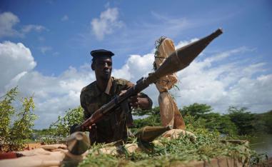 A Somali soldier holds a mortar gun at Sanguuni military base south of Mogadishu, Somalia.