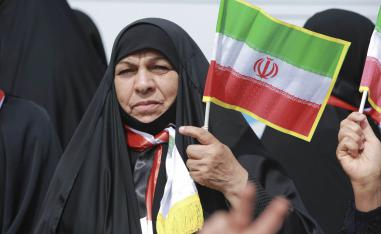 عراقية تحمل علما إيرانيا في تجمع للحشد الشعبي في بغداد