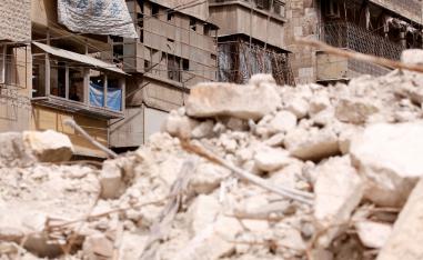 Malak Kasas' grandfather and uncle look out from their balcony overlooking rubble where she is still buried