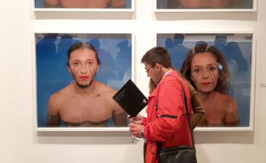 Visitors go through a booklet at the solo exhibition of Moroccan contemporary artist Mohamed El Baz in Casablanca