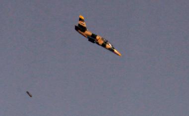 Israeli war plane dropping a payload above buildings in Syria