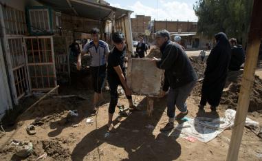 Iranians carry furnitures in a flooded street in the city of Poldokhtar in the Lorestan province, on April 02, 2019.